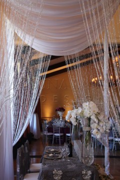 Elegant wedding setup with draped fabric and cascading crystal strands.