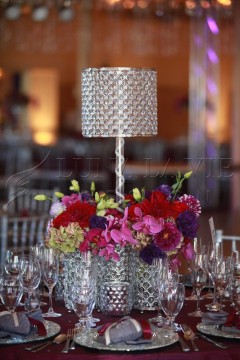 Elegant centerpiece with a crystal lamp and vibrant floral arrangement.