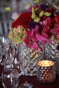 Elegant floral centerpiece with candlelight on a dining table.