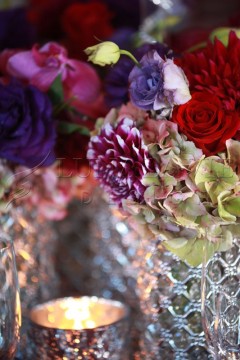 Close-up of vibrant mixed flowers with intricate glass vase.