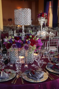 Elegant dining table with crystal glassware and vibrant floral centerpiece.