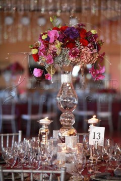 Elegant floral centerpiece with pink roses and dried flowers on a glass vase.