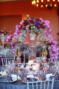 Elegant floral centerpiece with candles on a beautifully set table.