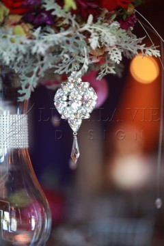 Elegant crystal pendant with intricate design and dangling teardrop.