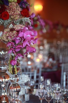 Elegant pink orchids in a glass vase at a formal event.