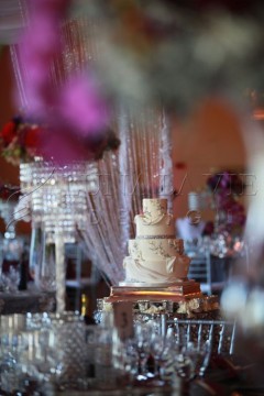 Elegant three-tiered wedding cake with floral decorations.