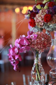 Elegant floral arrangement with pink orchids and mixed flowers in a glass vase.