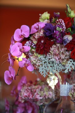 Elegant floral arrangement with pink orchids and mixed flowers in a crystal vase.