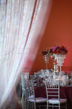 Elegant table setting with crystal centerpiece and pink floral arrangement.