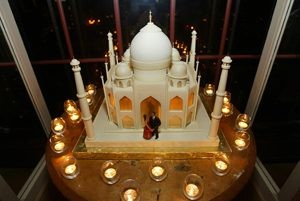 A detailed miniature model of the Taj Mahal surrounded by small candles.