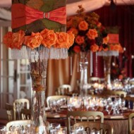 Elegant wedding table with orange roses and crystal decorations.