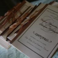 Elegant wedding invitations tied with brown ribbons.