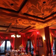 Warm, elegant restaurant interior with red drapes and ambient lighting.