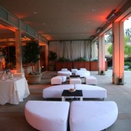 Elegant outdoor lounge with white seating and ambient lighting.