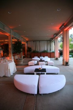Elegant outdoor lounge with white seating and ambient lighting.