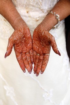 Hands adorned with intricate henna designs.