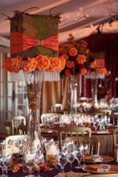 Elegant table setting with orange floral centerpieces and crystal accents.
