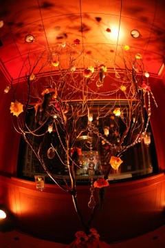 An artistic chandelier with intricate wires and glowing lights in a warm room.