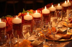 Elegant table setting with lit candles and glassware.