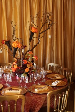 Elegant autumn-themed table setting with floral centerpiece and warm tones.