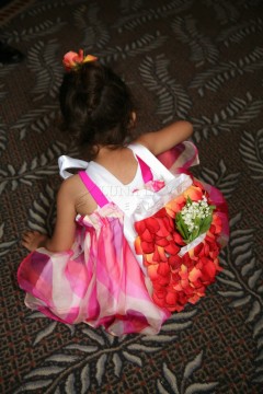 A little girl in a pink dress holding a bouquet of flowers.