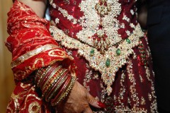 Intricate bridal jewelry and henna-adorned hands in traditional attire.