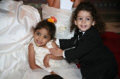 Young children dressed formally, smiling and posing together.