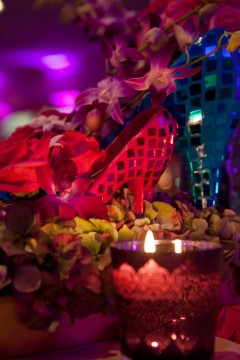 A vibrant candlelit arrangement with pink flowers and decorative elements.