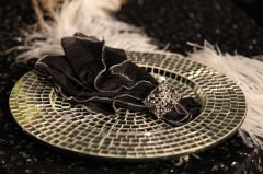 Elegant black napkin with silver ring on patterned plate.