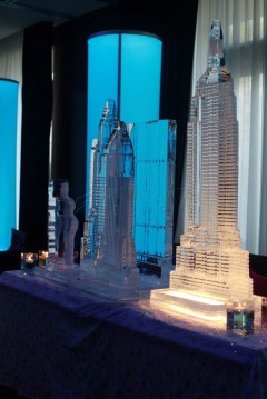 Illuminated architectural models displayed on a table with blue lighting.