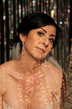 Woman with dramatic shadow patterns on her face and shoulders.