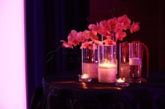 Elegant pink orchids in glass vases with candles.