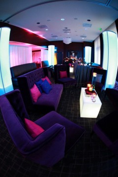 Luxurious lounge with purple velvet seating and ambient lighting.