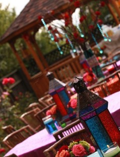 Colorful lanterns decorate an outdoor seating area with a cozy wooden gazebo.