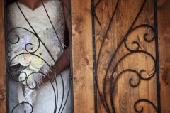 Close-up of wrought iron gate with wooden panel.