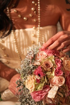 Bride holding a bouquet of pastel roses and pearls.
