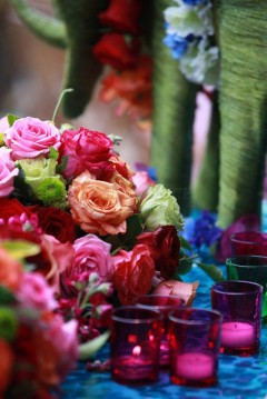 A vibrant bouquet of colorful roses with assorted glass cups.