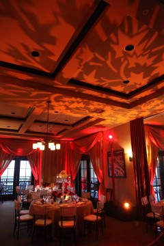 Cozy restaurant interior with warm lighting and red curtains.