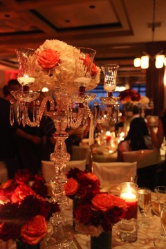 Elegant chandelier centerpiece with roses on a dimly lit table.